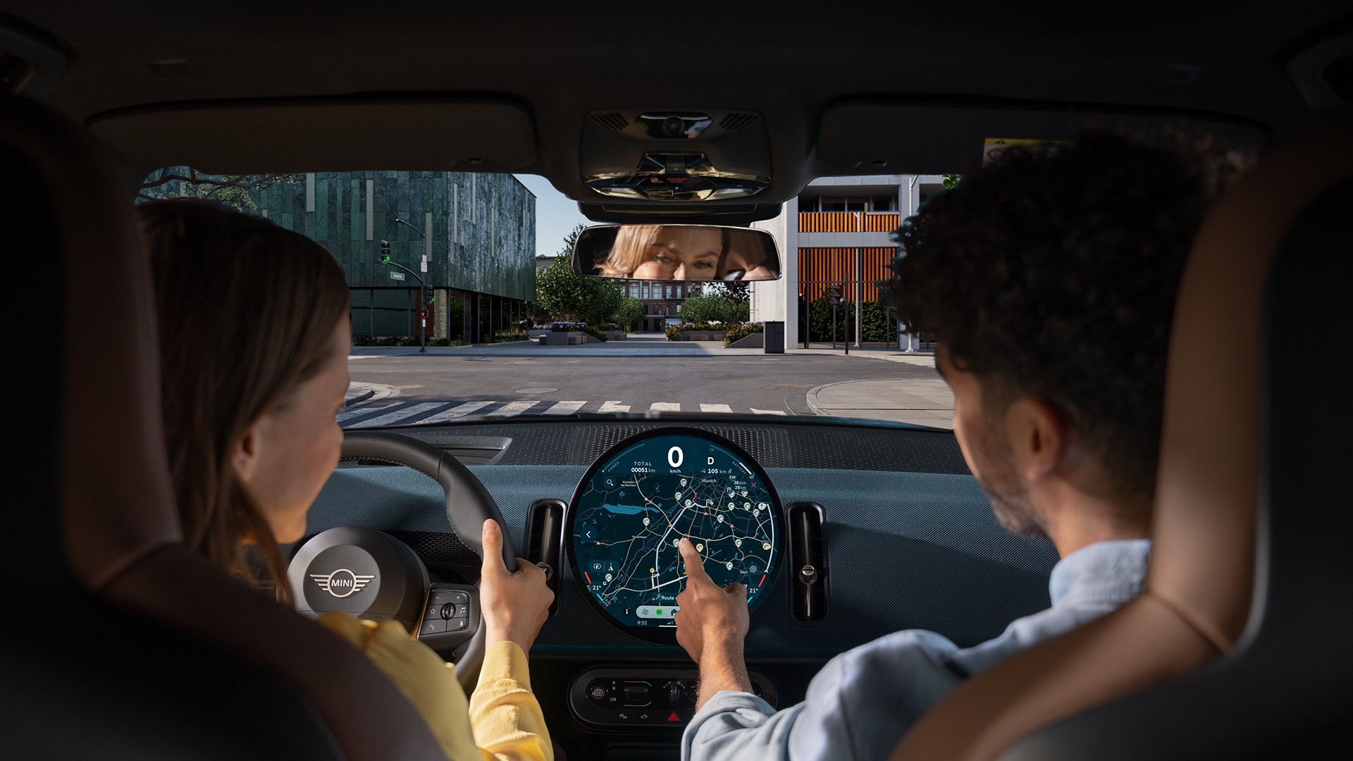 Una persona è seduta al volante di una MINI. Gli elementi grafici simboleggiano la varietà dell'offerta MINI Connected.